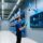 Modern warehouse with RFID-enabled pallet tracking, handheld scanner in use, fixed reader mounted on racking, clean industrial lighting