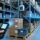 Professional warehouse scene showing UHF RFID reader scanning metal shelving with RFID tags on cartons and pallets