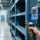Professional industrial scene showing certified RFID tags on metal assets, handheld scanner, and fixed RFID reader in a clean, well-lit warehouse environment