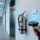 Professional close-up of UHF RFID tag mounted on fire extinguisher cylinder in modern UAE high-rise corridor, with handheld RFID scanner nearby