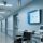 Professional healthcare setting with RFID readers, tagged hospital wheelchair and infusion pump, clean modern hospital corridor, blue-gray corporate palette