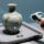 Professional studio photo of museum artifact RFID tagging: ceramic vase with discreet HF RFID inlay, handheld scanner, clean background, blue-gray palette