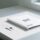 Paper-based RFID tag on a clean white desk next to a printed EU compliance document, symbolizing green electronics import compliance